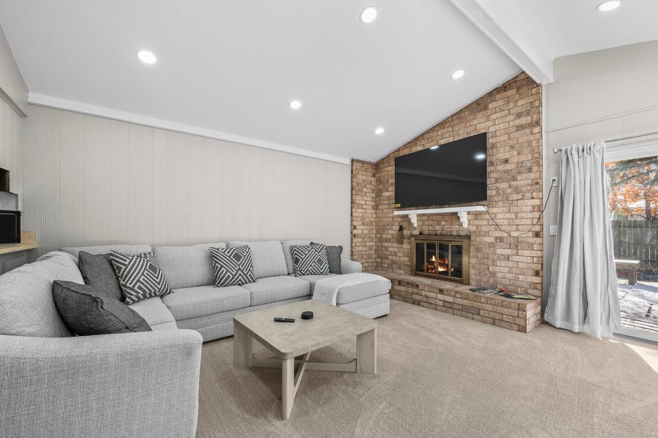 A comfortable seating area centered around the fireplace and TV.