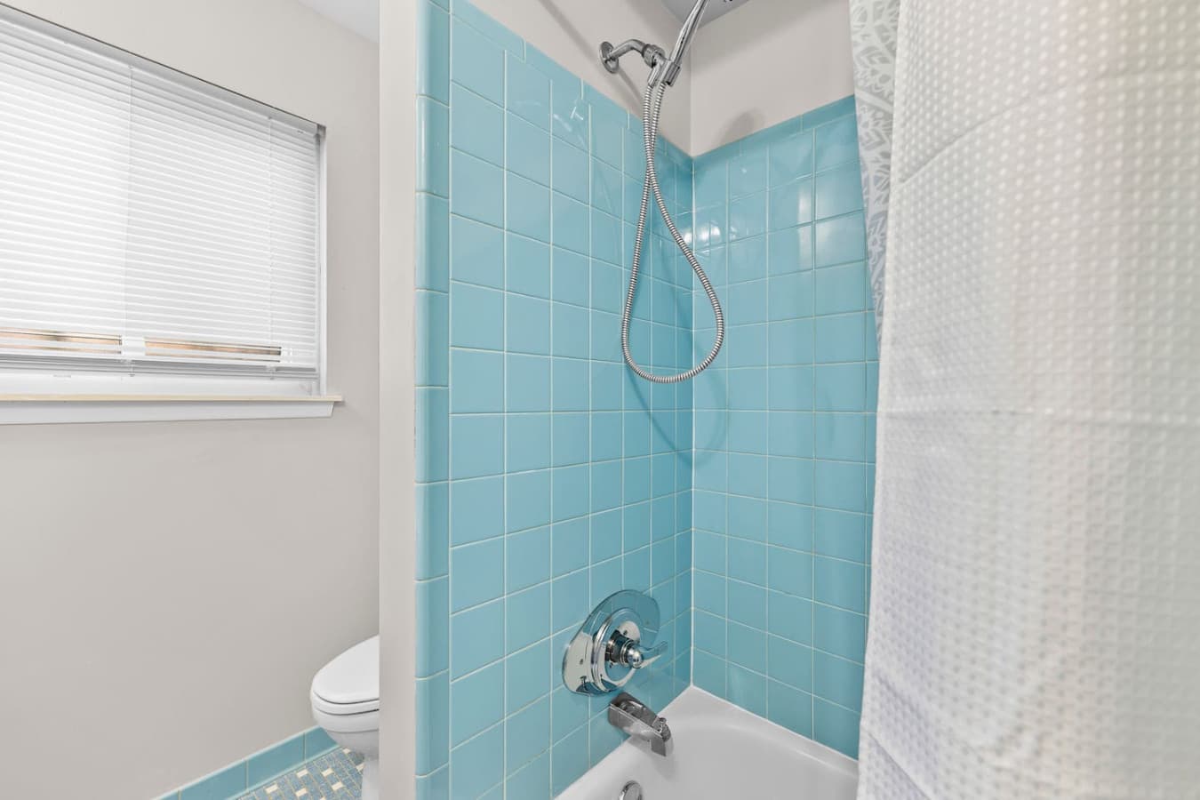 A bright bathroom with colorful tile accents and a clean design.