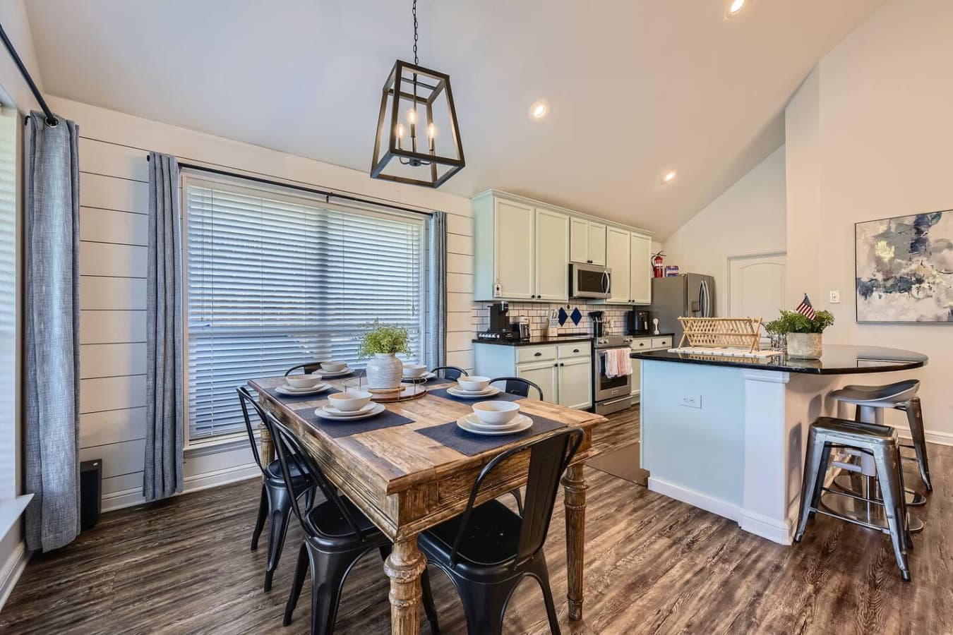 The dining area features its own TV, a farmhouse table, and seating for six.