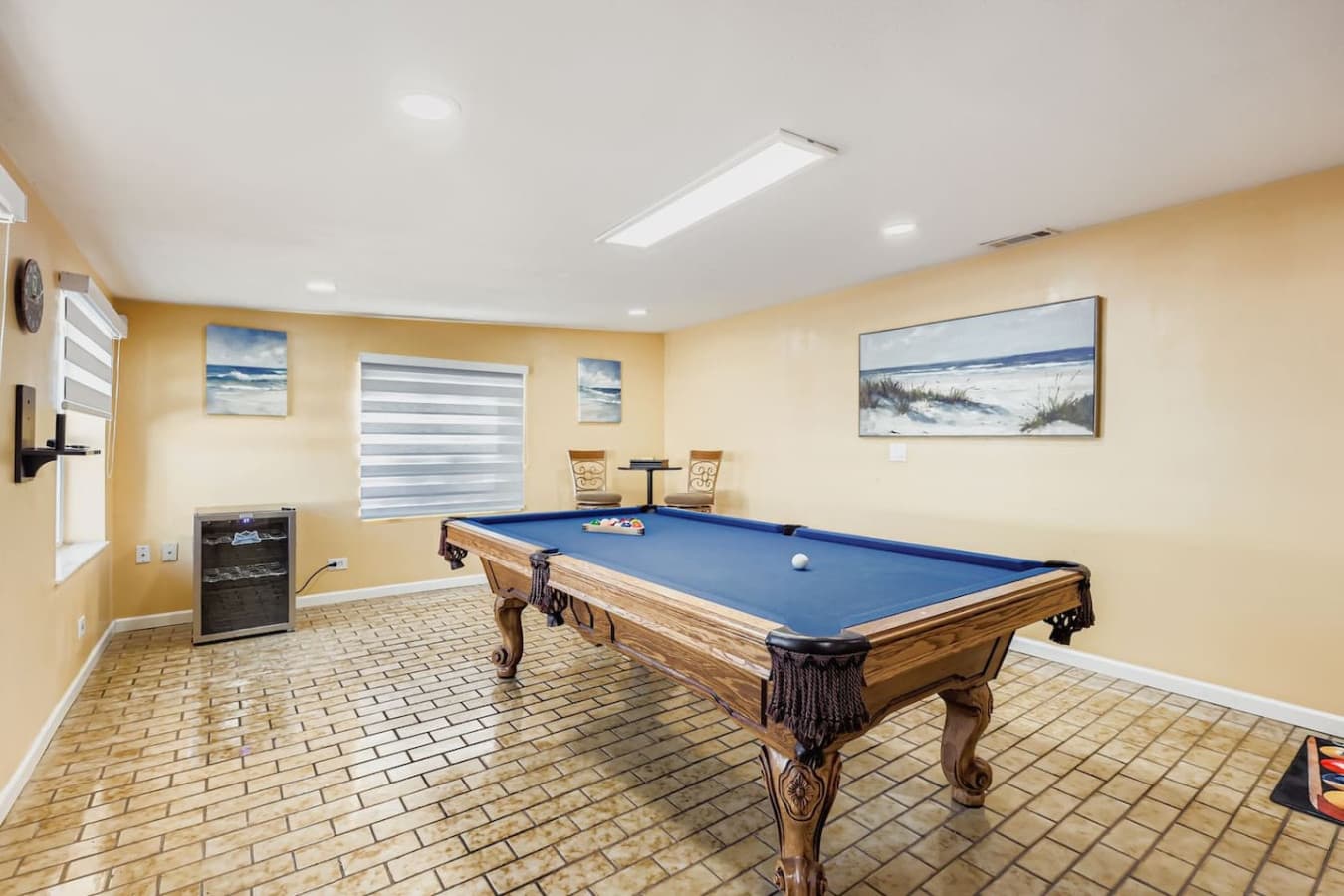 Spacious and sunlit game room with a classic pool table for endless entertainment.