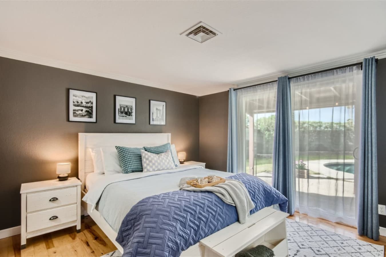 Bedroom one featured on the main level with a queen size bed and direct backyard access.