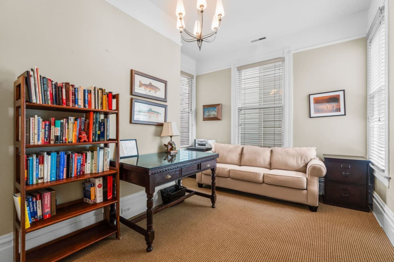 Third room with a dedicated workspace and sofa.