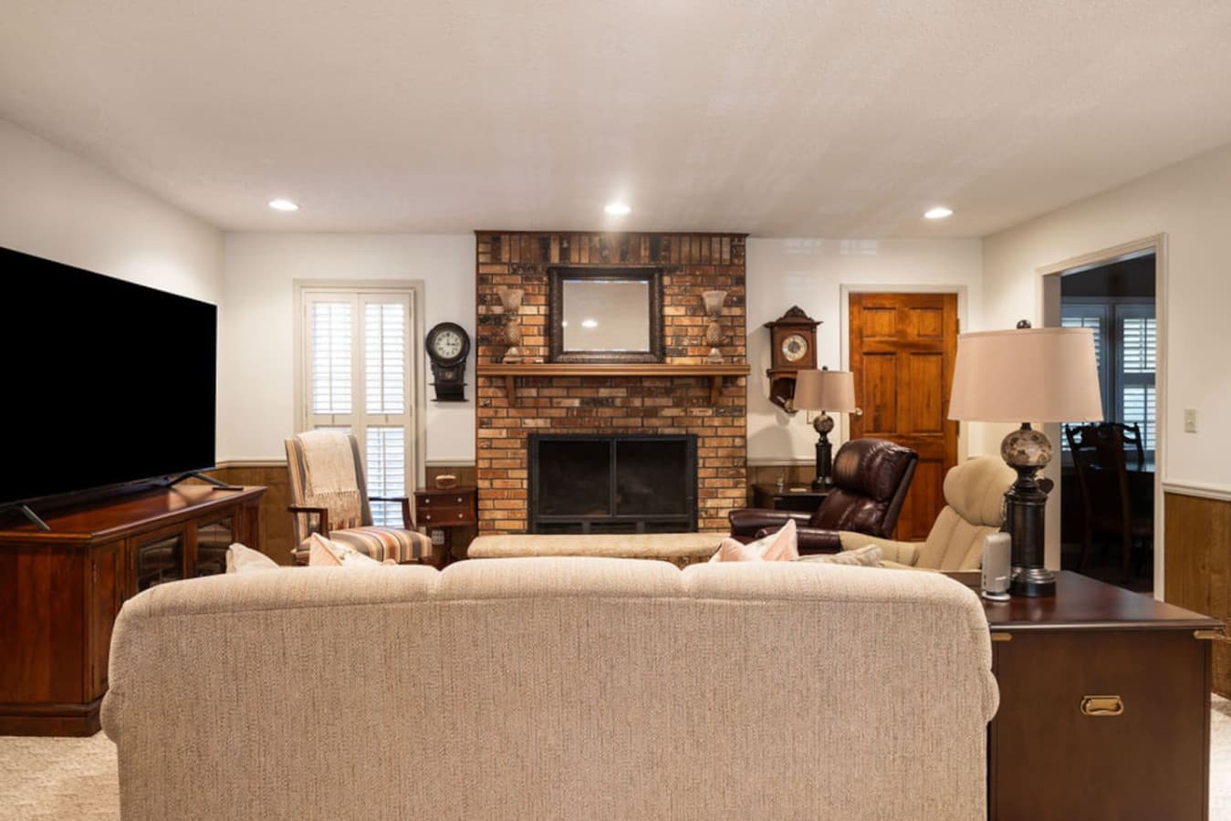A warm and inviting lounge featuring a classic brick fireplace as the centerpiece.