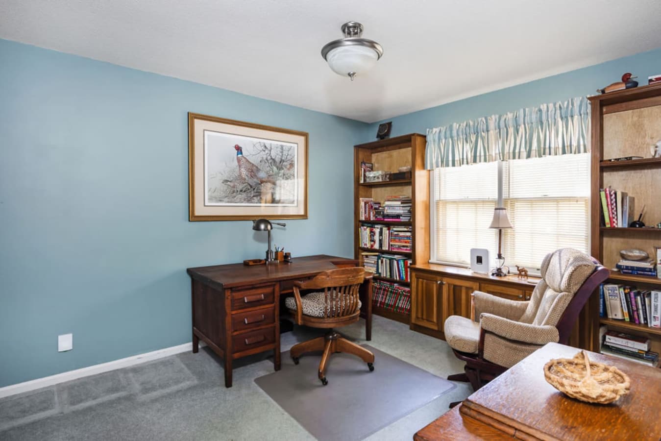 A quiet workspace with a desk and bookshelf ideal for reading or remote work.