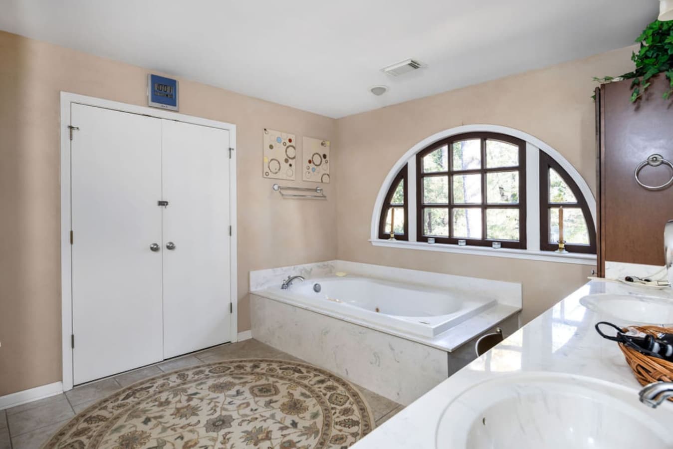 A bright bathroom with a large soaking tub and soft natural light.
