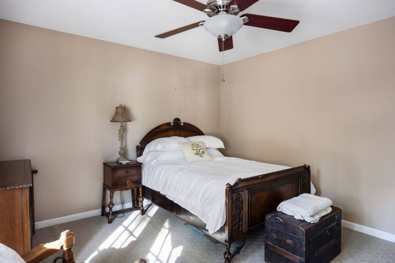 A classic bedroom with elegant wood furnishings and natural light.