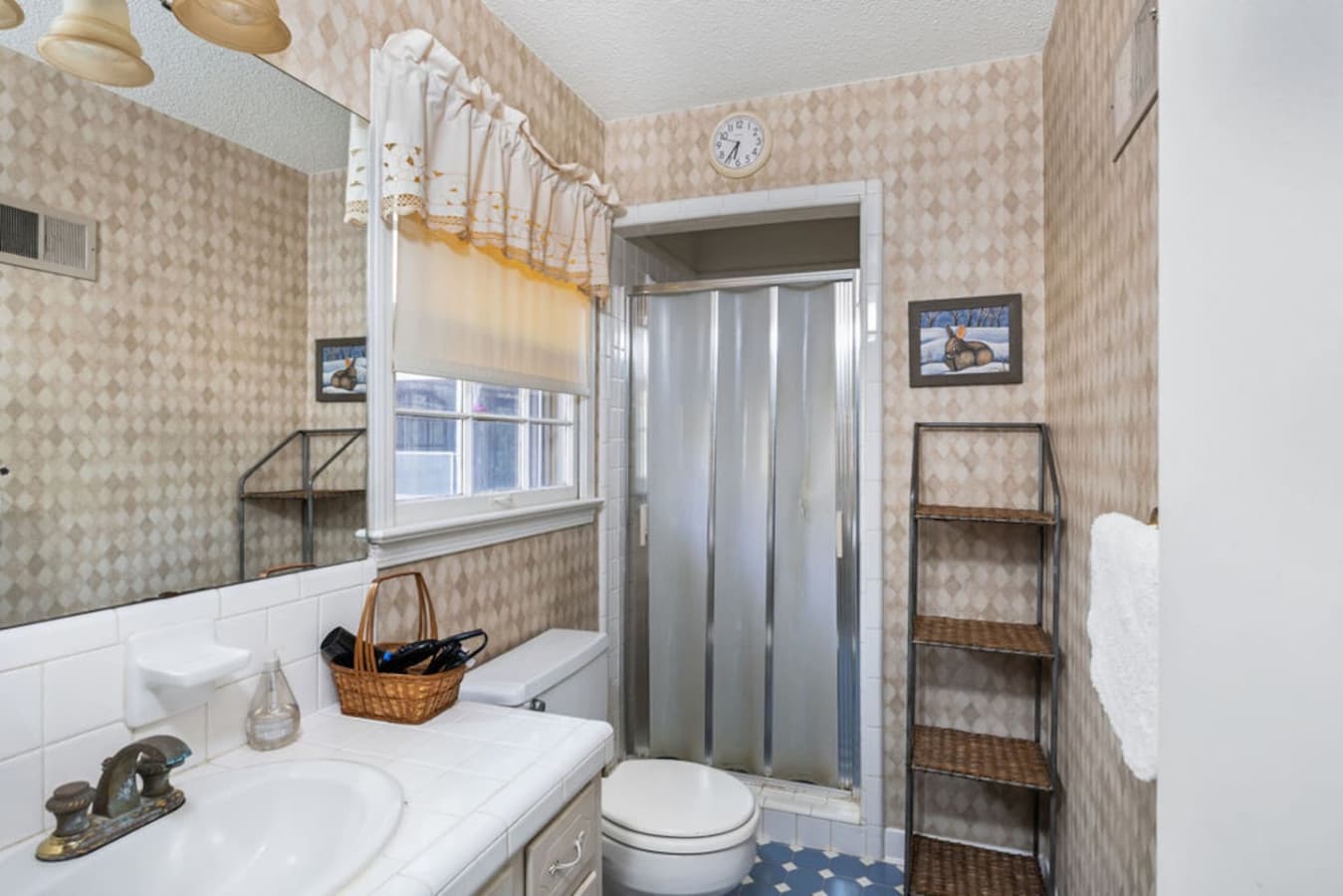 A compact bathroom with a walk-in shower and bright natural light.