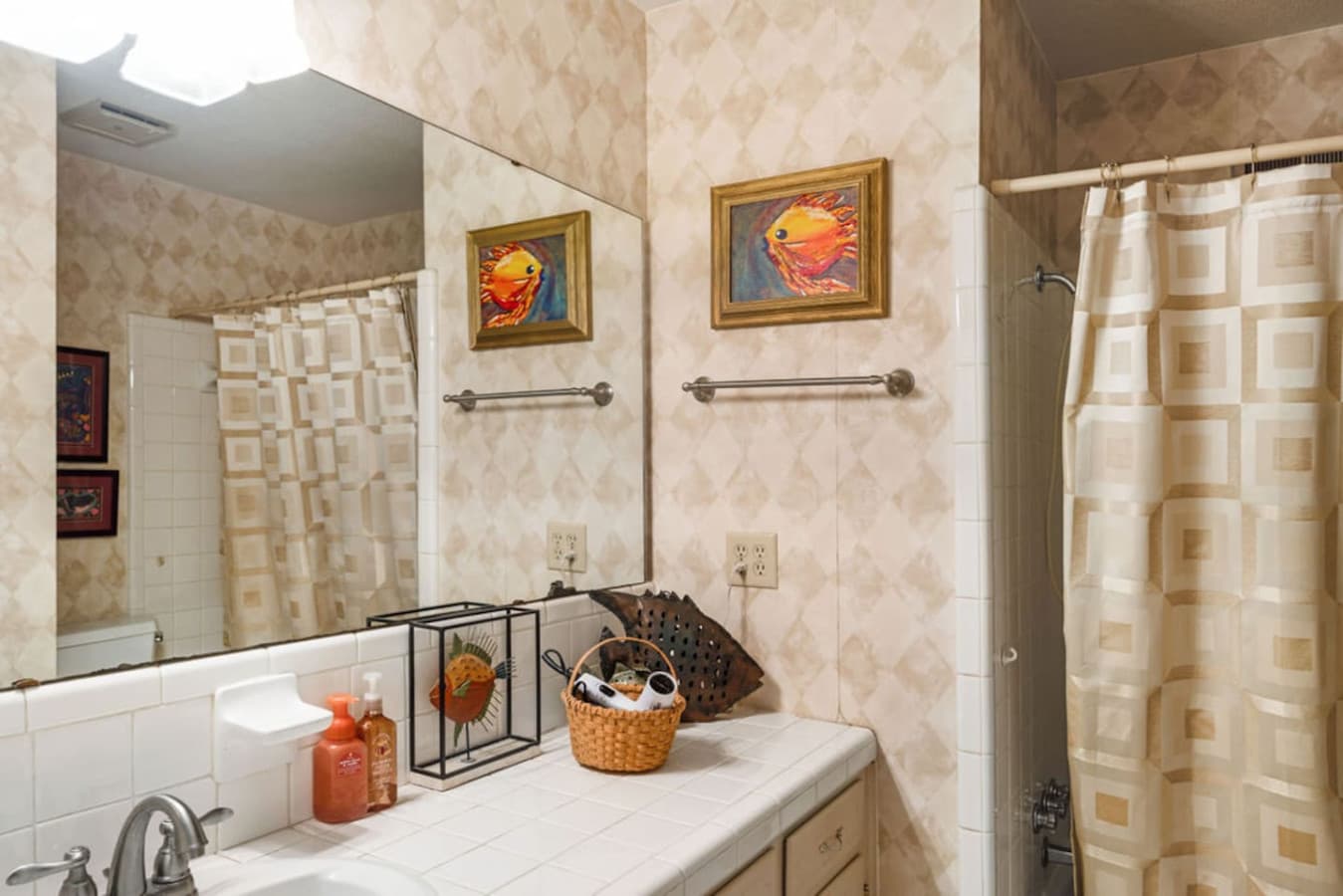 A clean bathroom with a wide mirror and convenient counter space.