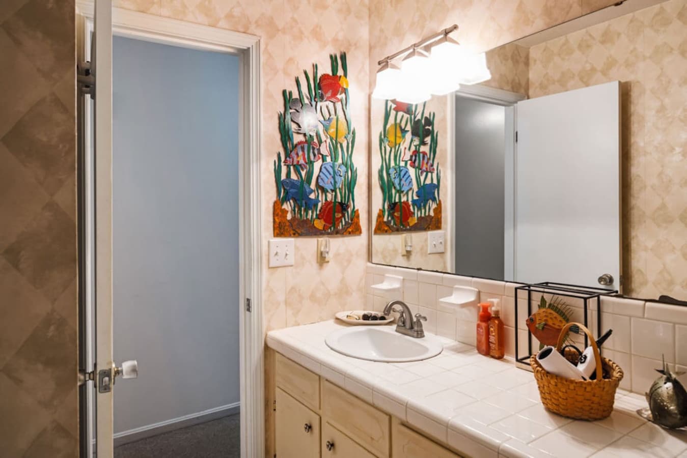 A bright bathroom with colorful artwork and a simple vanity setup.