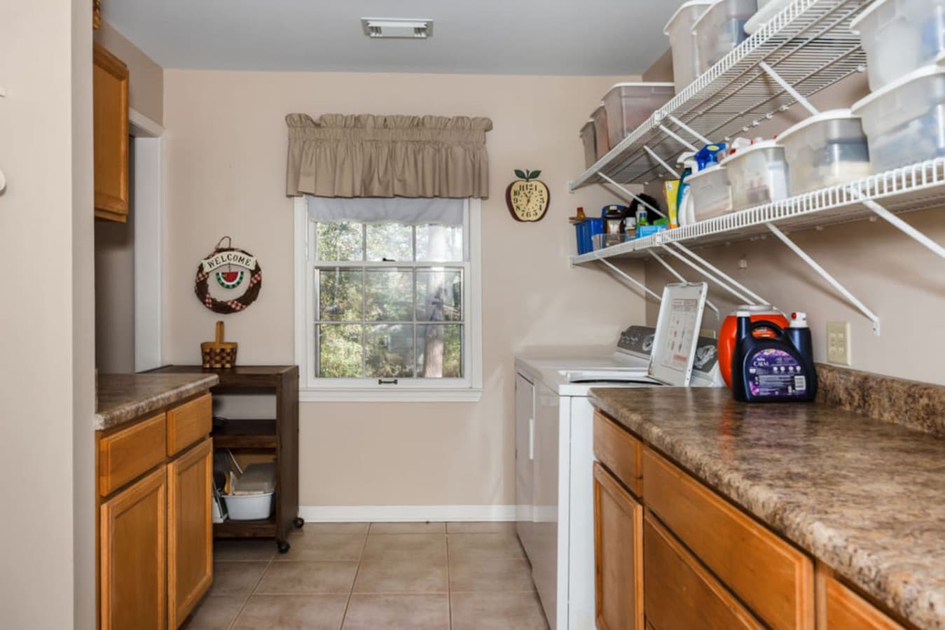 A well organized laundry room with plenty of counter space and shelving.