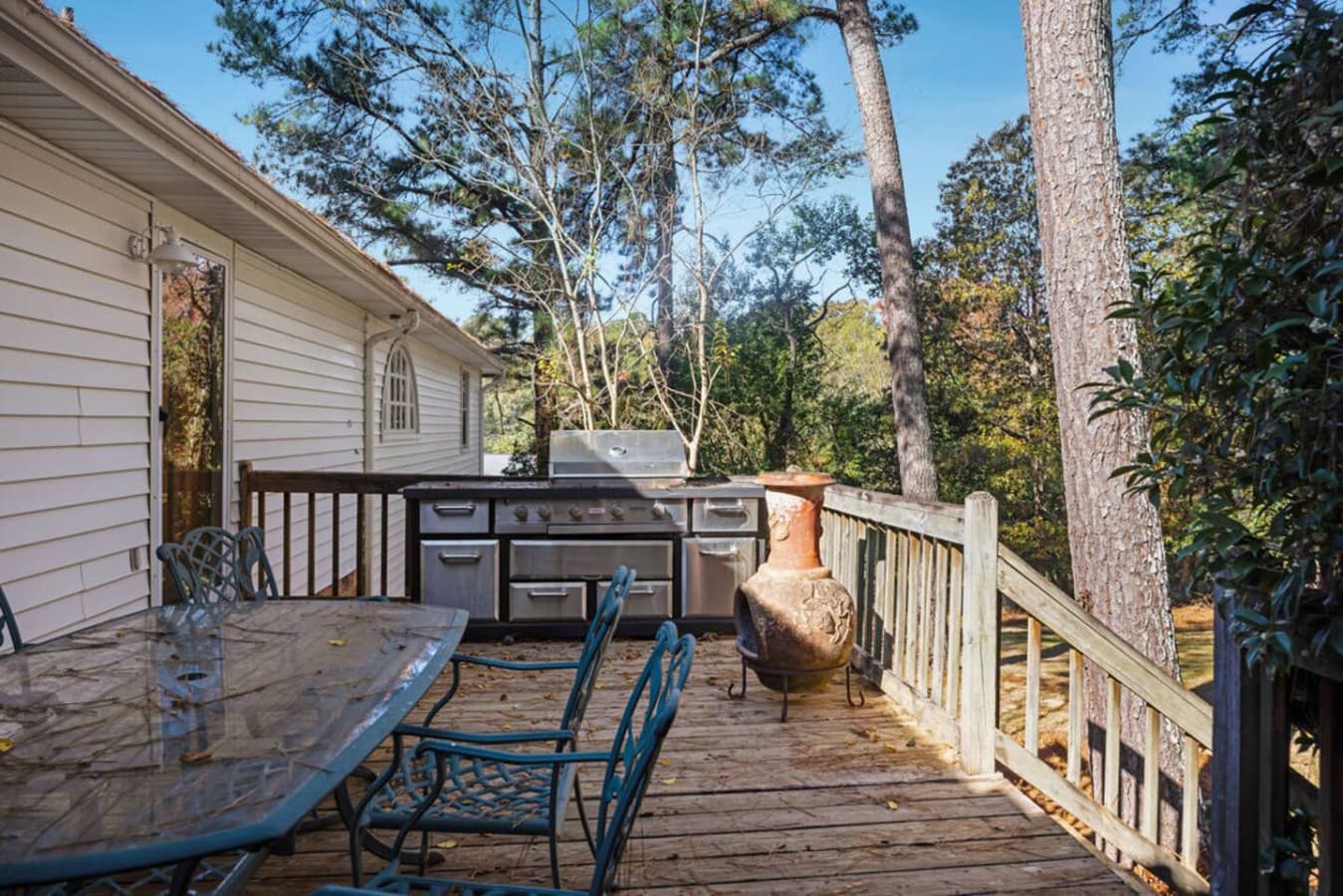 A cozy deck with a grill and outdoor dining area.