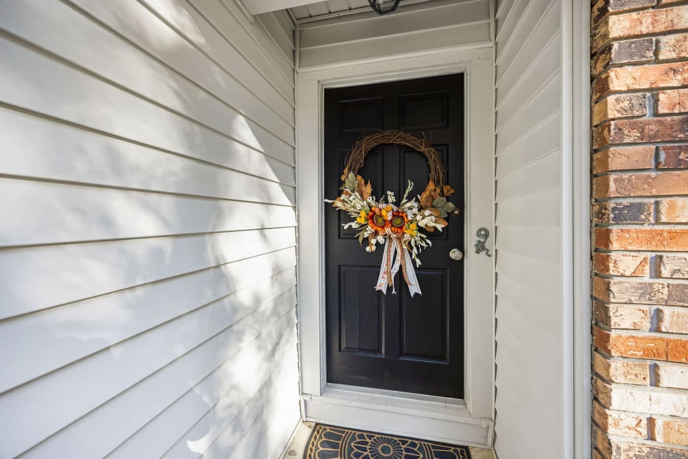 A bright and inviting front door with seasonal decor.
