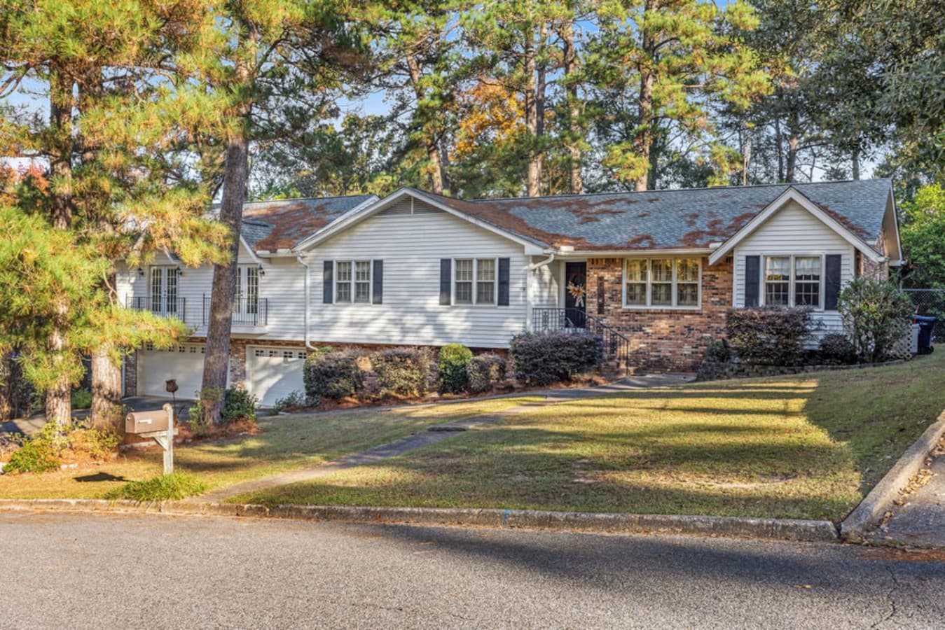 A welcoming exterior with mature trees and charming curb appeal.