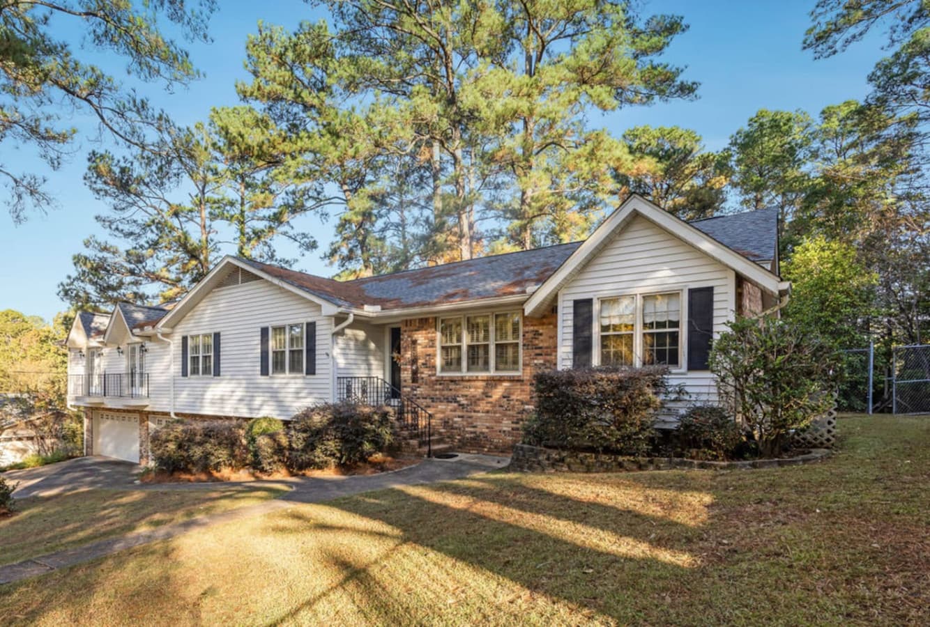 A charming exterior with brick accents and mature landscaping.