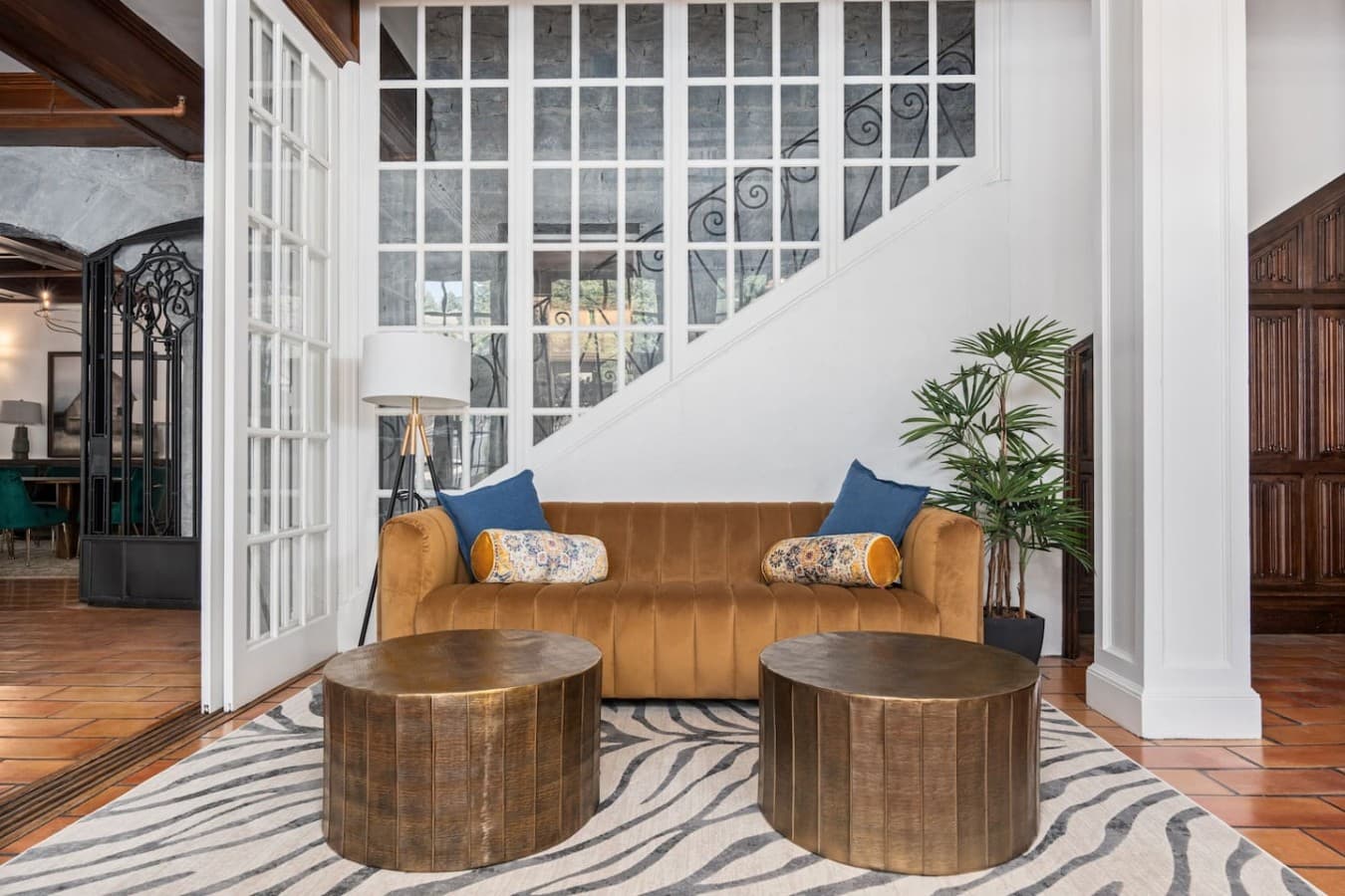 A stylish shared lounge by the staircase with plush seating and soft lighting located in the hotel’s common space and not inside your private room.