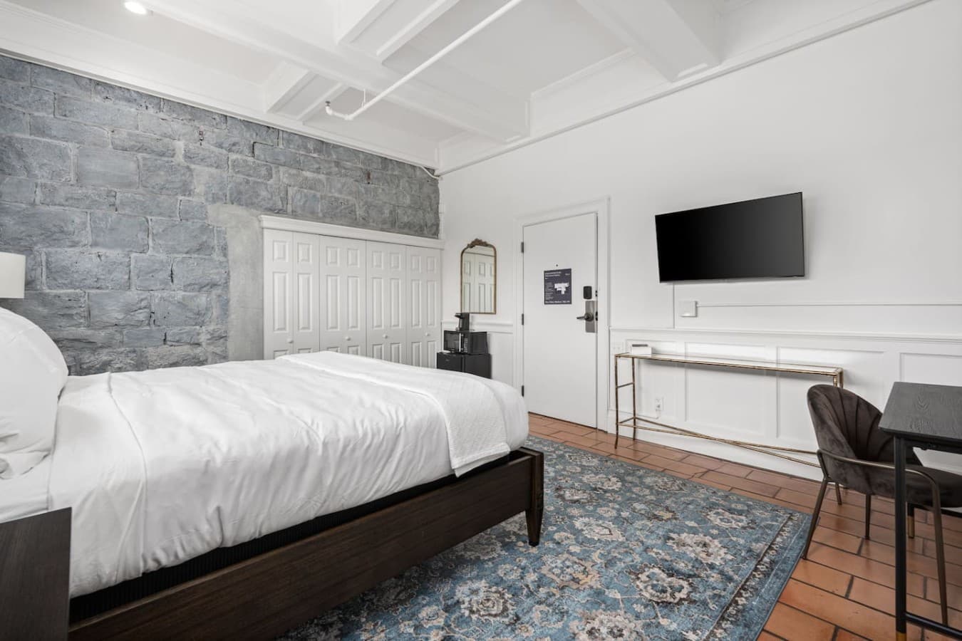 This is the private room you will be renting offering a bright space with a king bed, work area, and mounted TV.