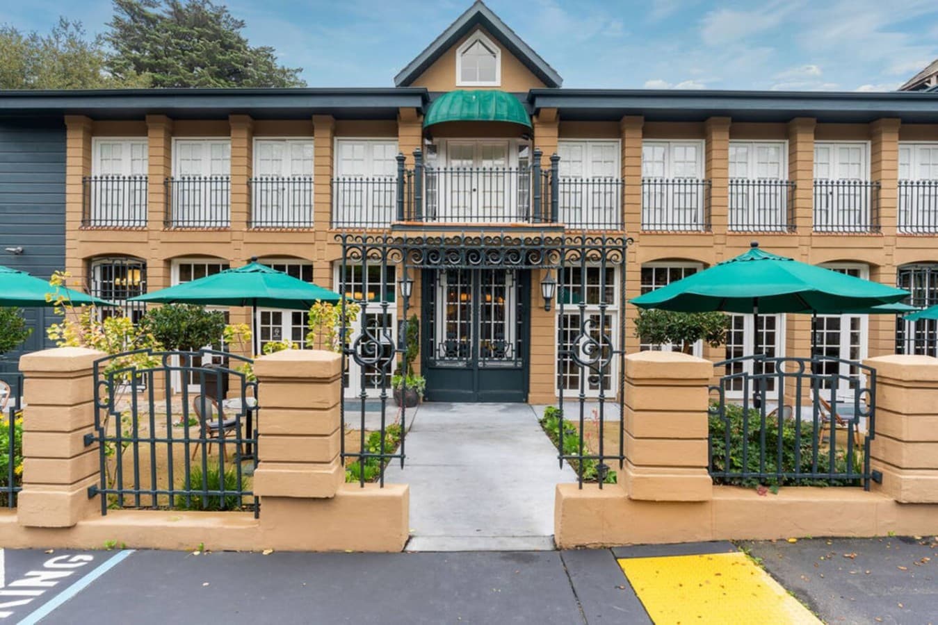 The welcoming main entrance framed by tall windows and vibrant garden paths.