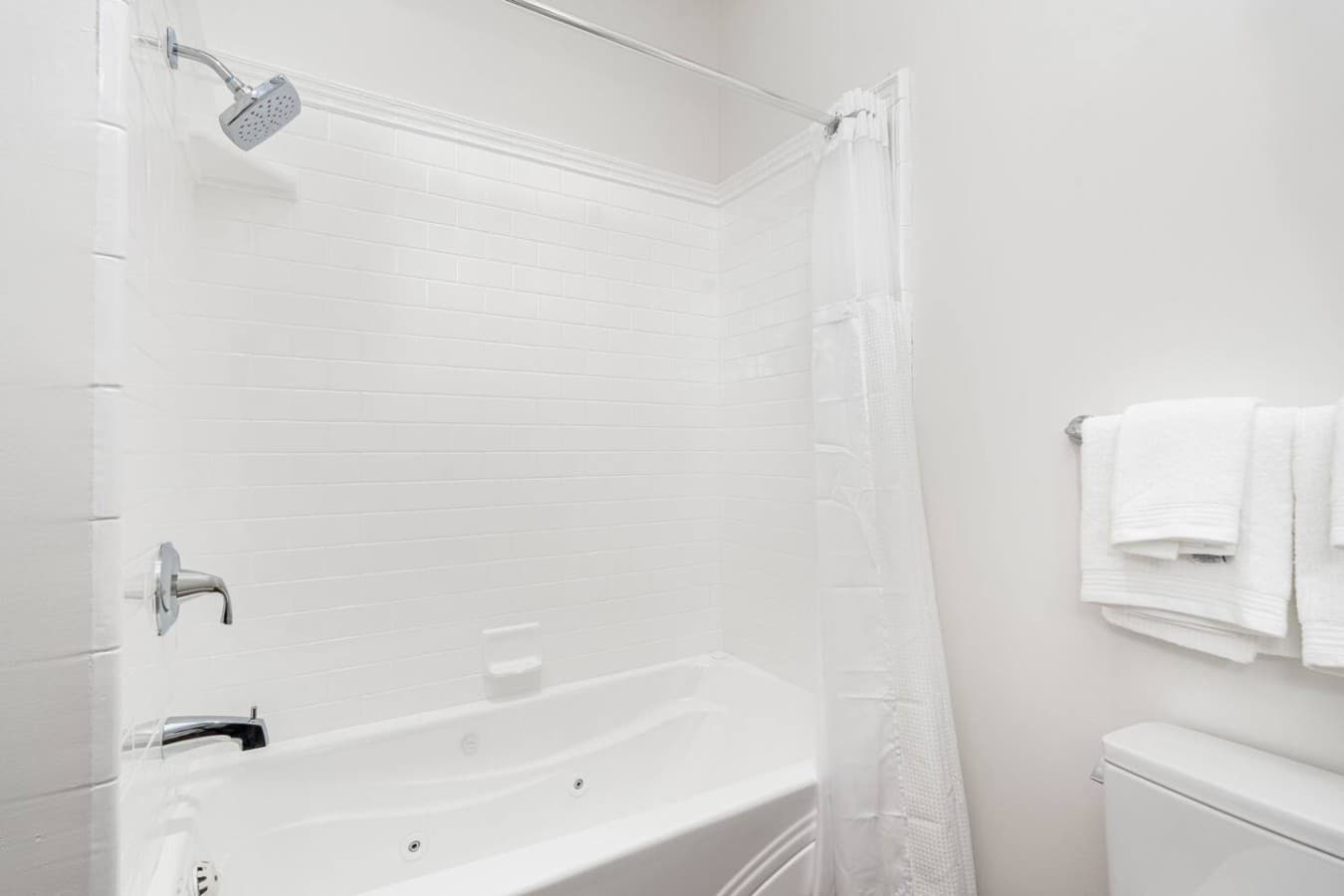 A clean private bath and shower combination offering a relaxing spot to unwind.
