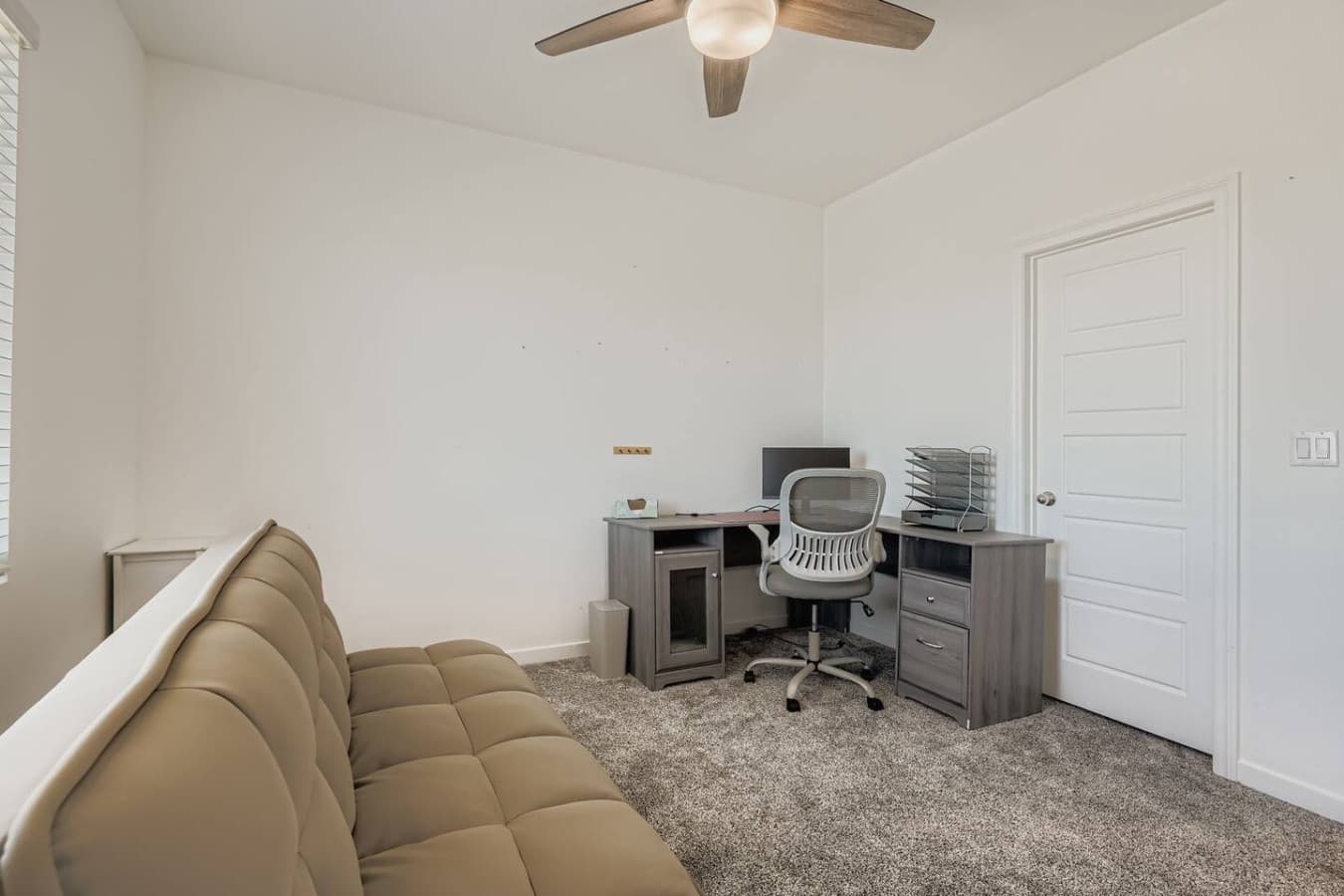 Third bedroom features a dedicated workspace and futon bed.