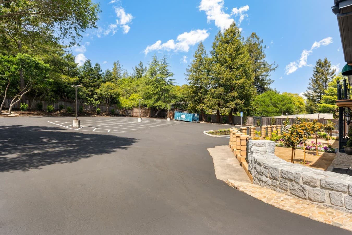 A spacious parking lot surrounded by mature trees providing convenient on-site parking for guests.