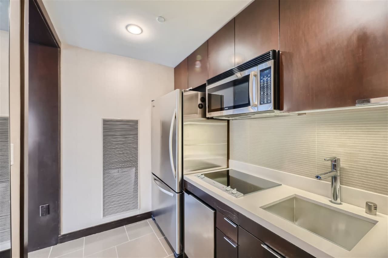 The kitchen featuring a stove, refrigerator, microwave, laundry machine, dryer and a dining area.