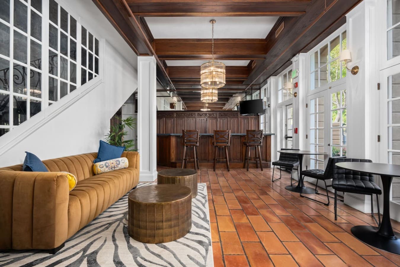 A warm shared living area with wood beams, natural light, and comfortable seating located in the hotel’s common space and not inside your private room.