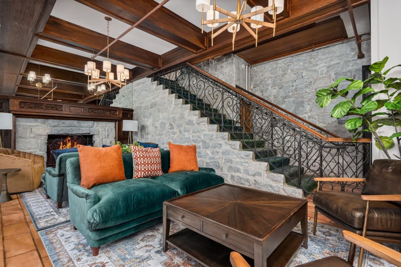 A shared gathering area by the grand staircase with vibrant seating and warm textures located in the hotel’s common space and not inside your private room.