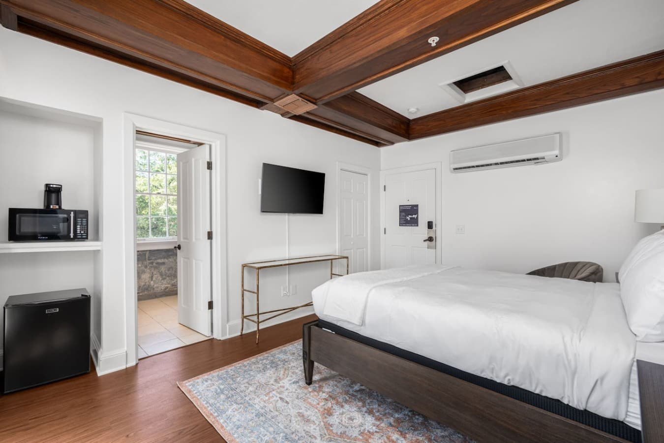 This is the private room you will be renting featuring a spacious layout, wood-beam ceilings, and a comfortable bed.