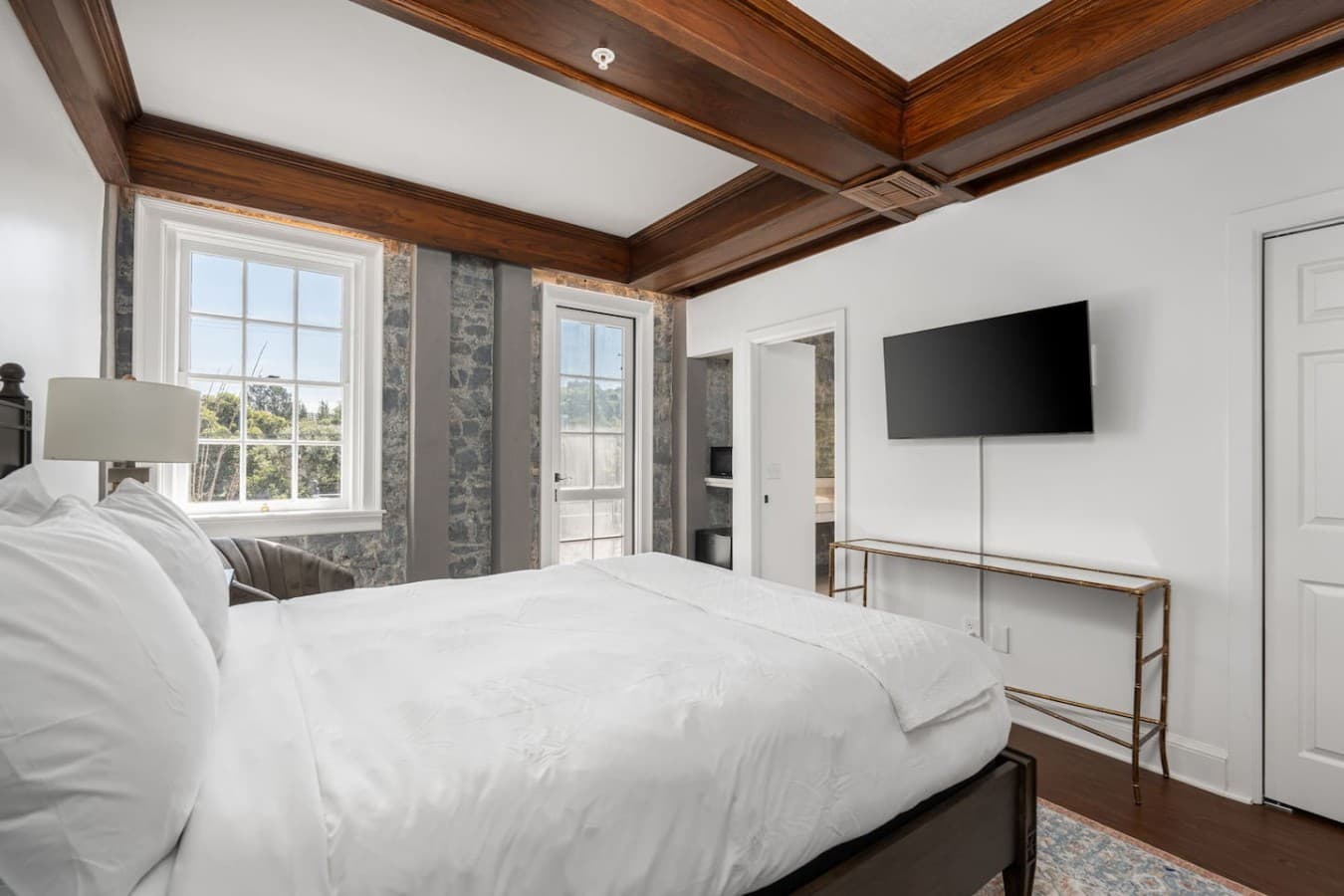 This is the private room you will be renting offering bright natural light, a mounted TV, and elegant stone-accented walls.