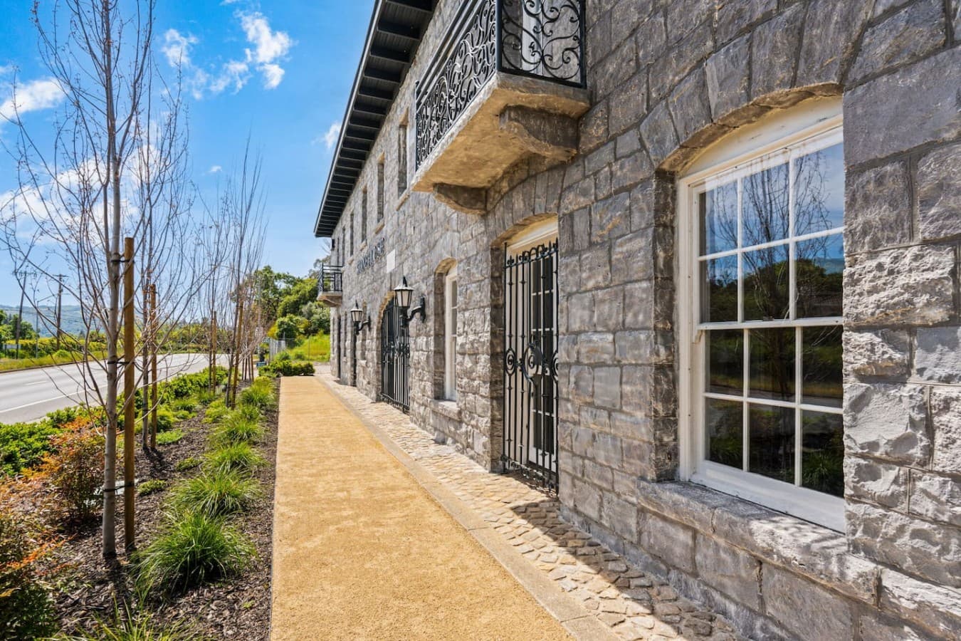 A peaceful side pathway highlighting the hotel’s historic stone exterior and garden landscaping.