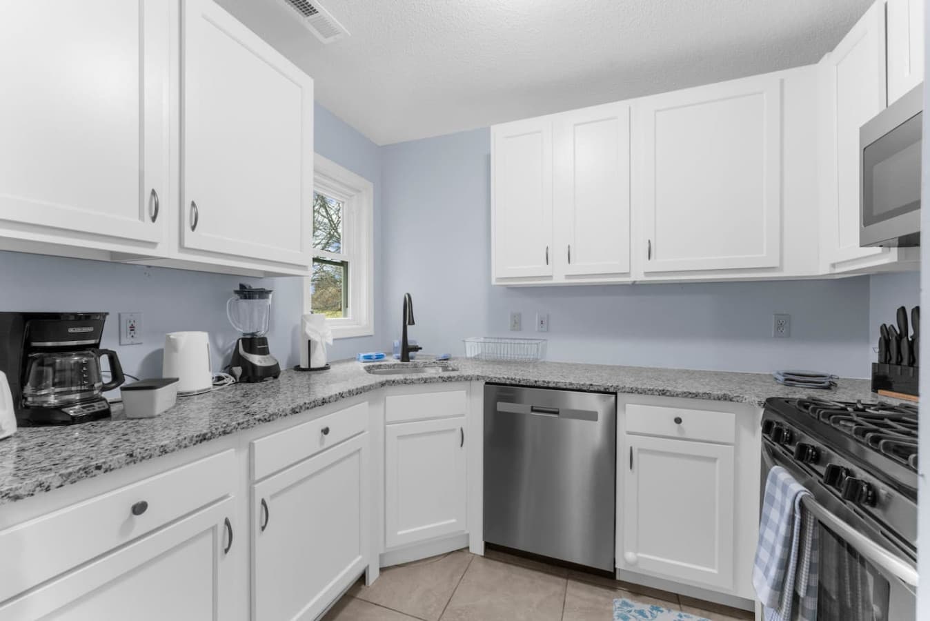 Bright kitchen with white cabinets and ample counter space.