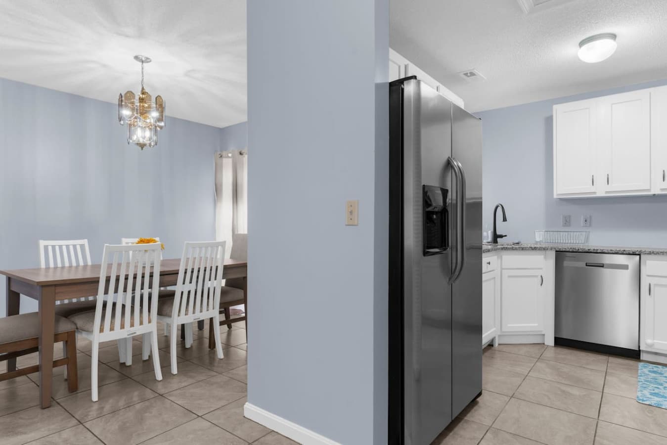 Stainless steel refrigerator beside the dining area.