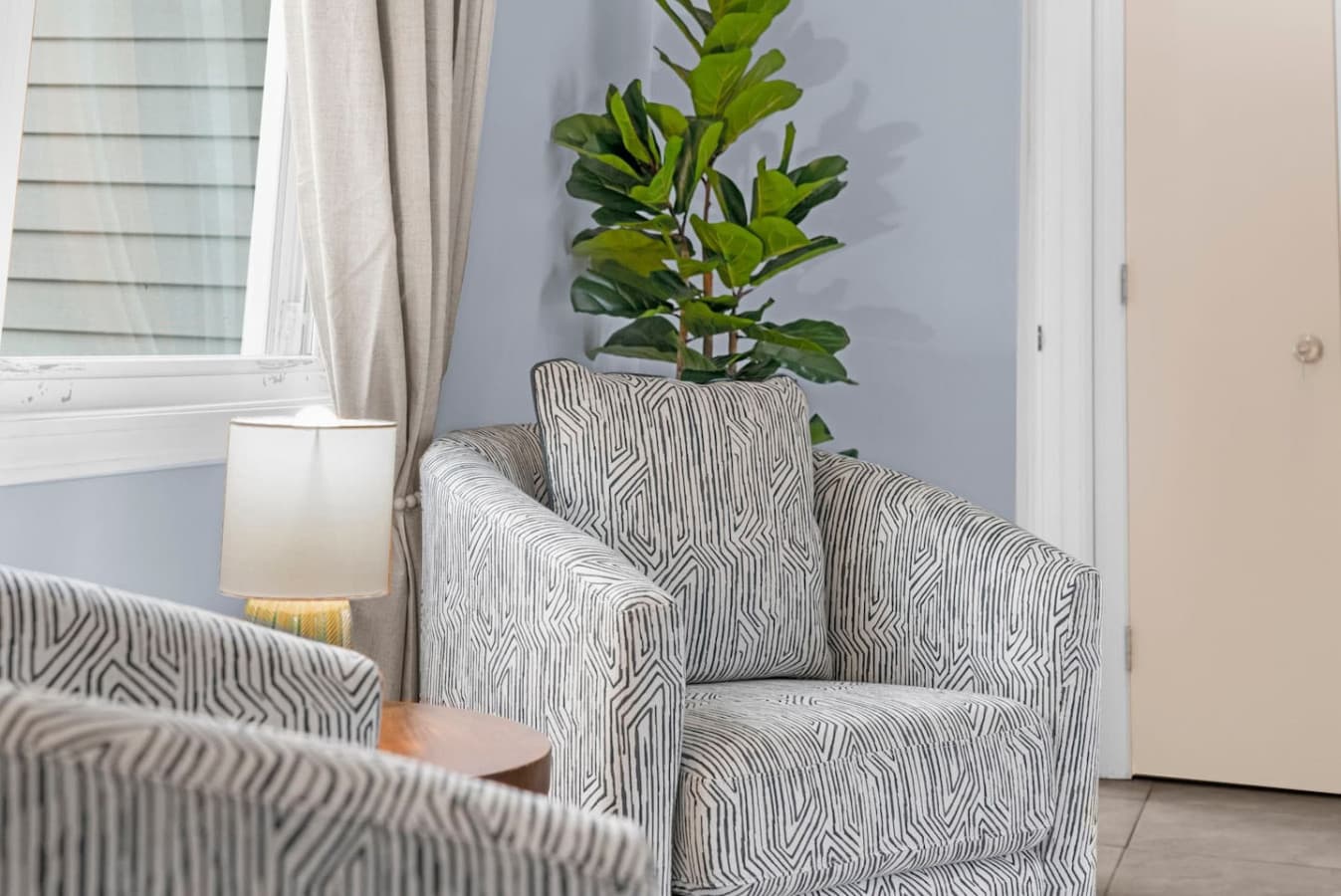Seating corner with a patterned chair and greenery for a calm atmosphere.