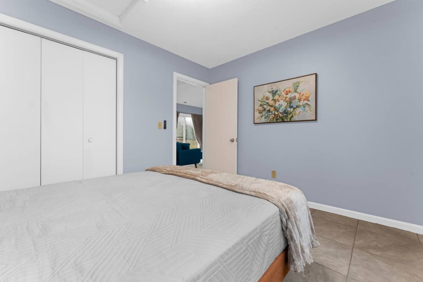 Clean bedroom view with a spacious closet and calming décor.
