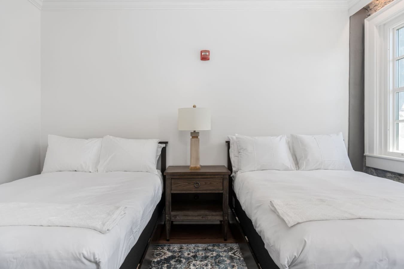 This is the private room you will be renting showcasing two double beds with simple, clean design and cozy bedding.