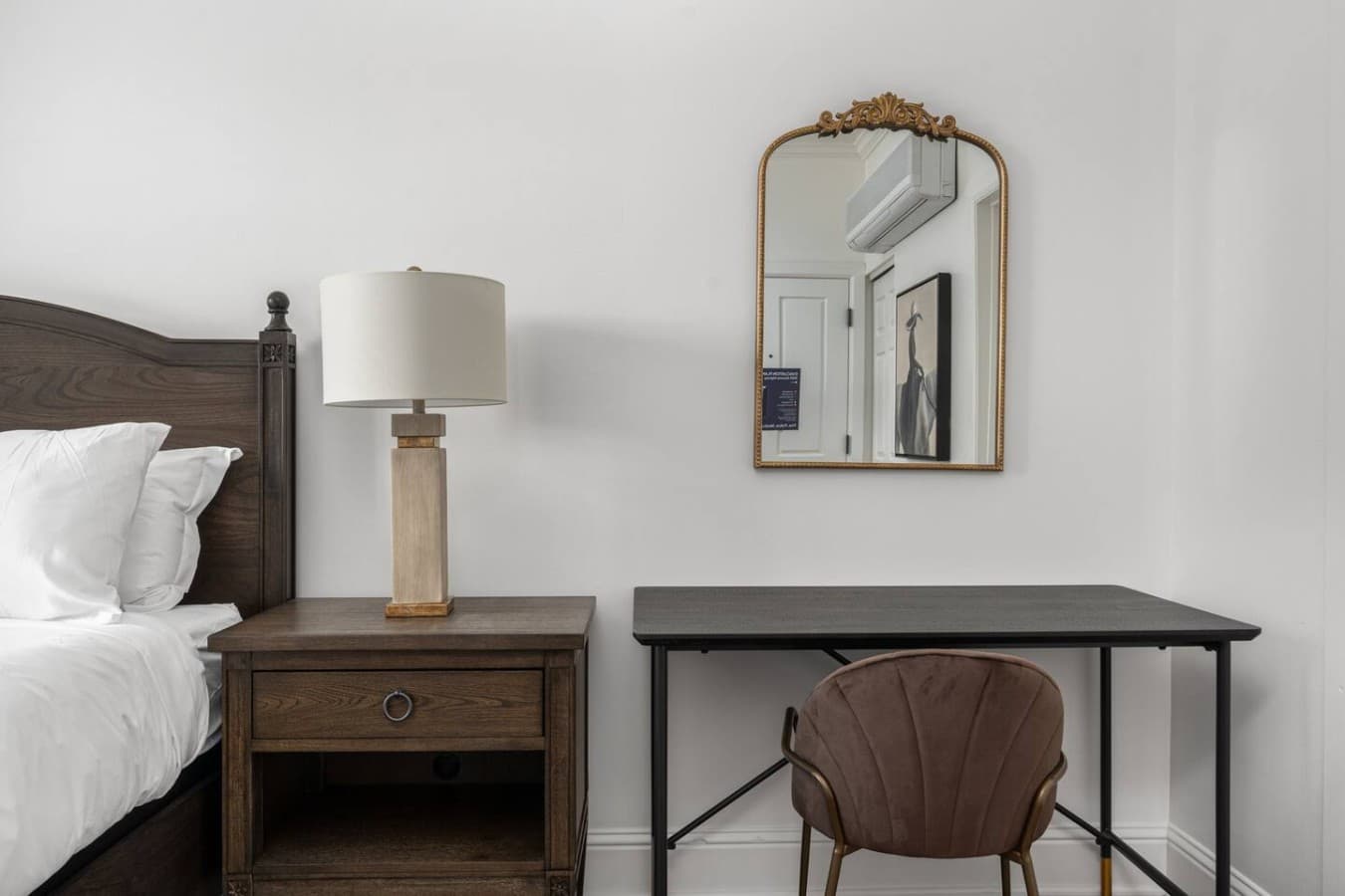 This is the private room you will be renting featuring a dedicated workspace, elegant mirror, and simple modern furnishings.