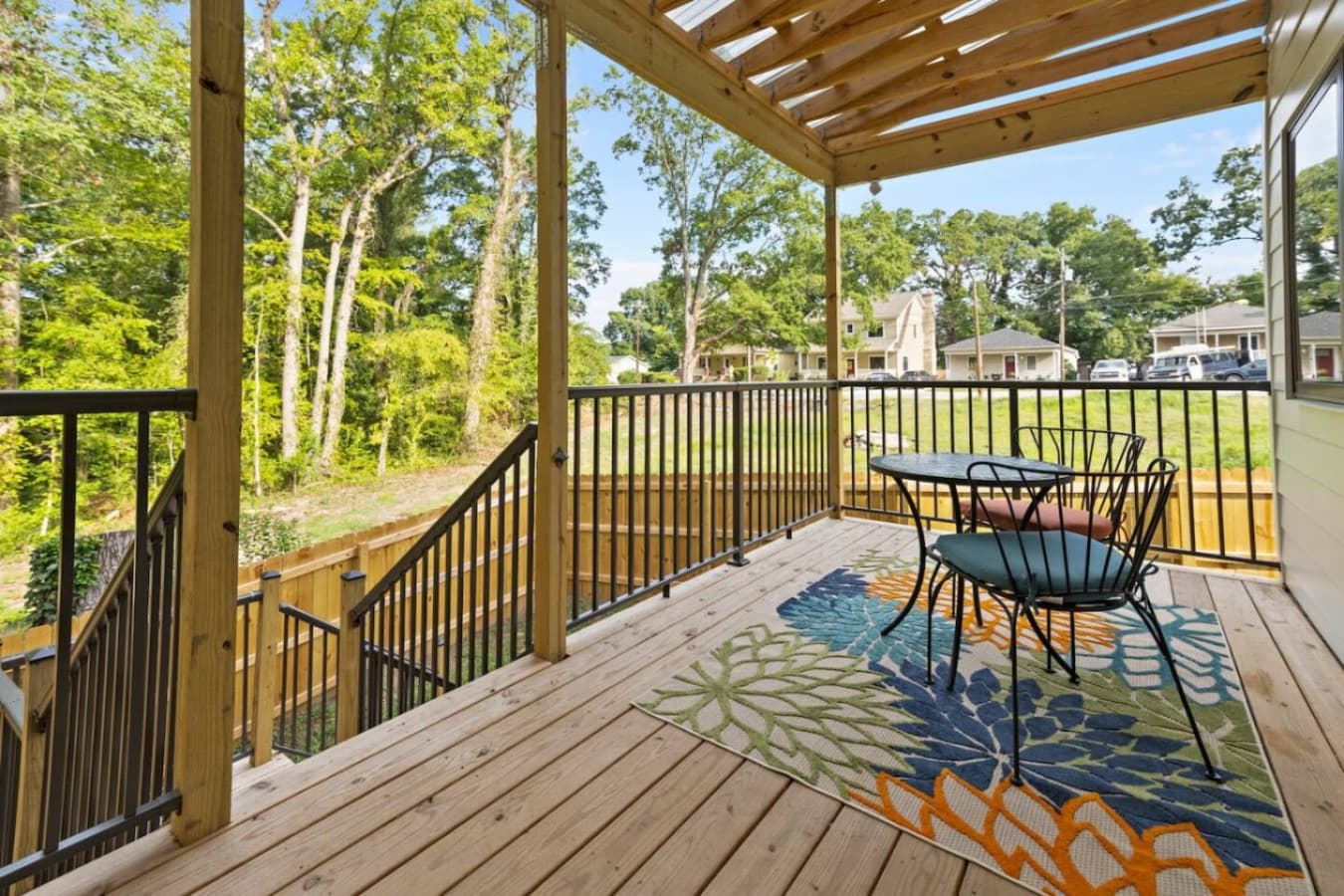 Unit B: Charming covered back porch with peaceful views of the fenced yard and surrounding trees.