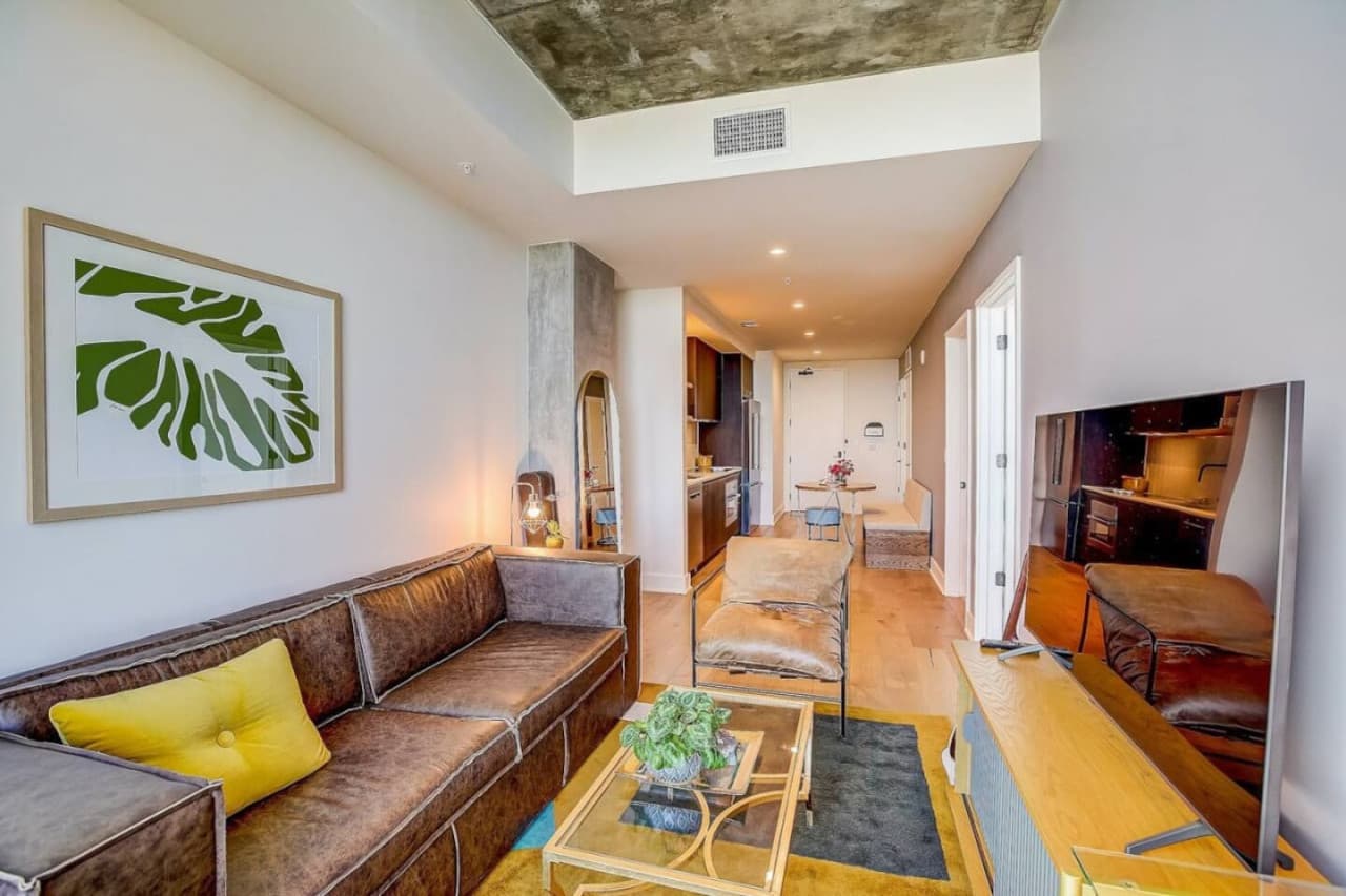 A spacious living room flooded with natural light through a grand, expansive window