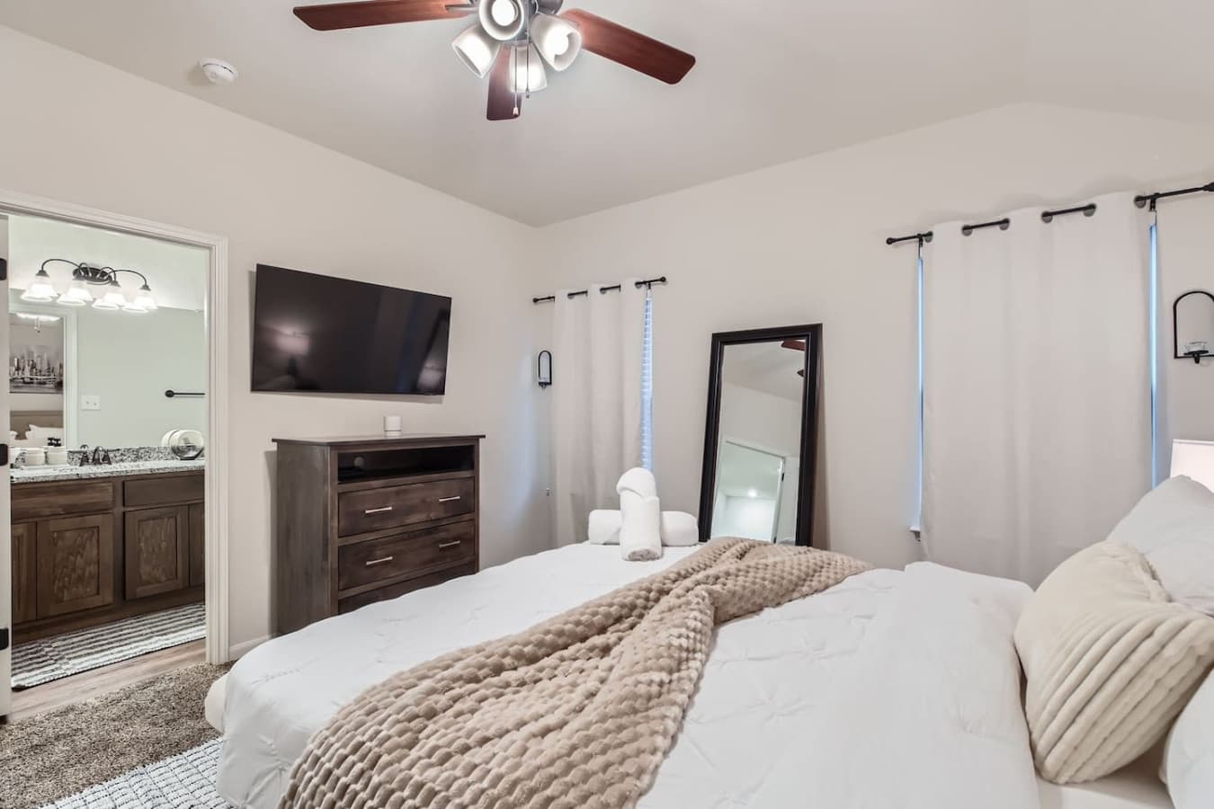 The master bedroom boasts a queen bed, a Smart TV for entertainment, and a private ensuite bathroom.