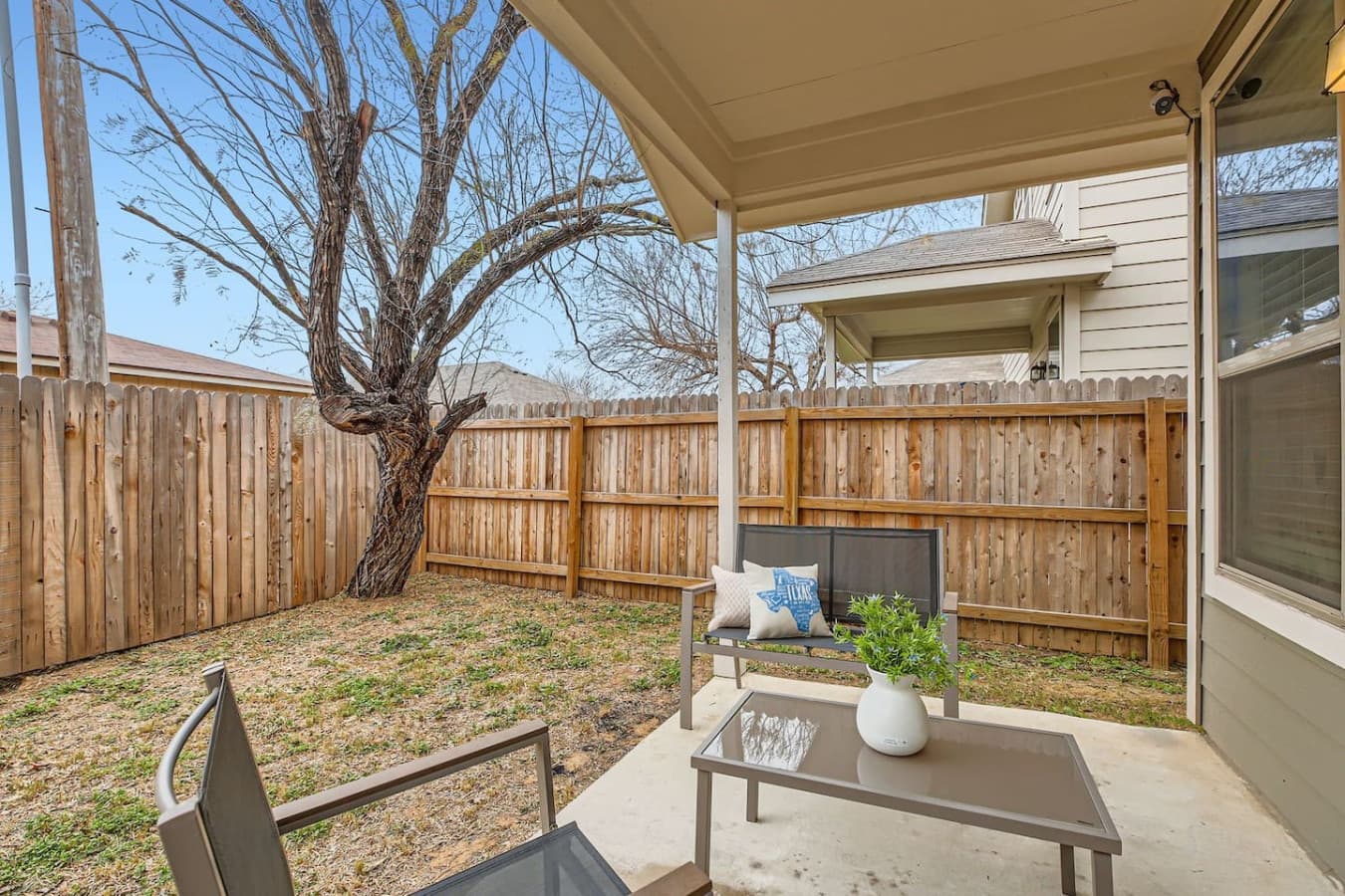 Fully fenced backyard, complete with outdoor seating.