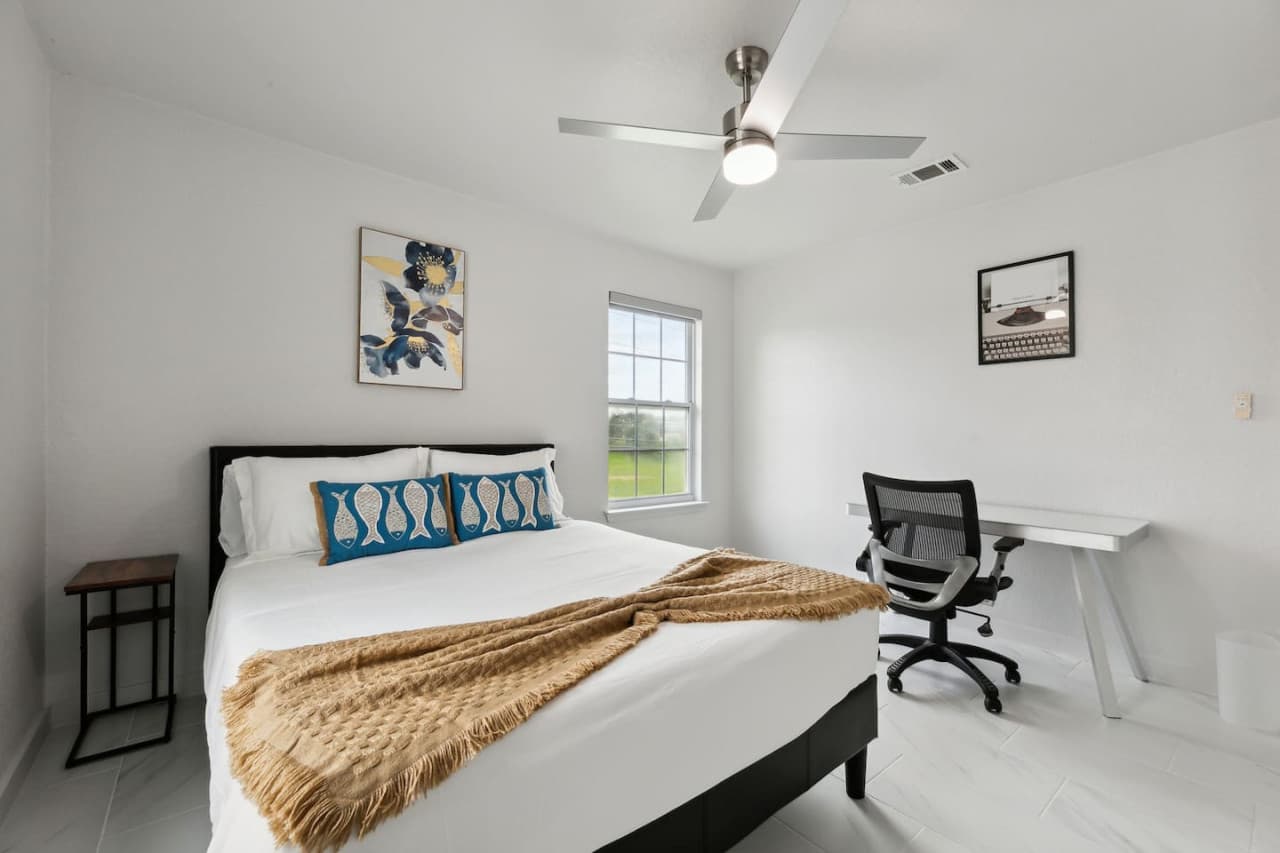 Third bedroom featuring a queen size bed and work station.