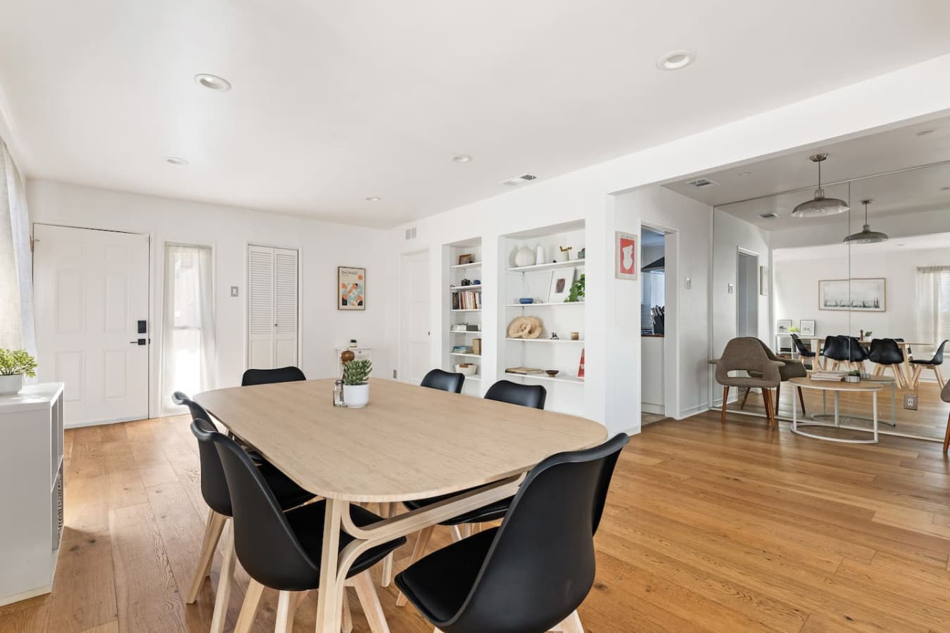 Bright open dining space with warm wood floors and seamless flow into the living areas.