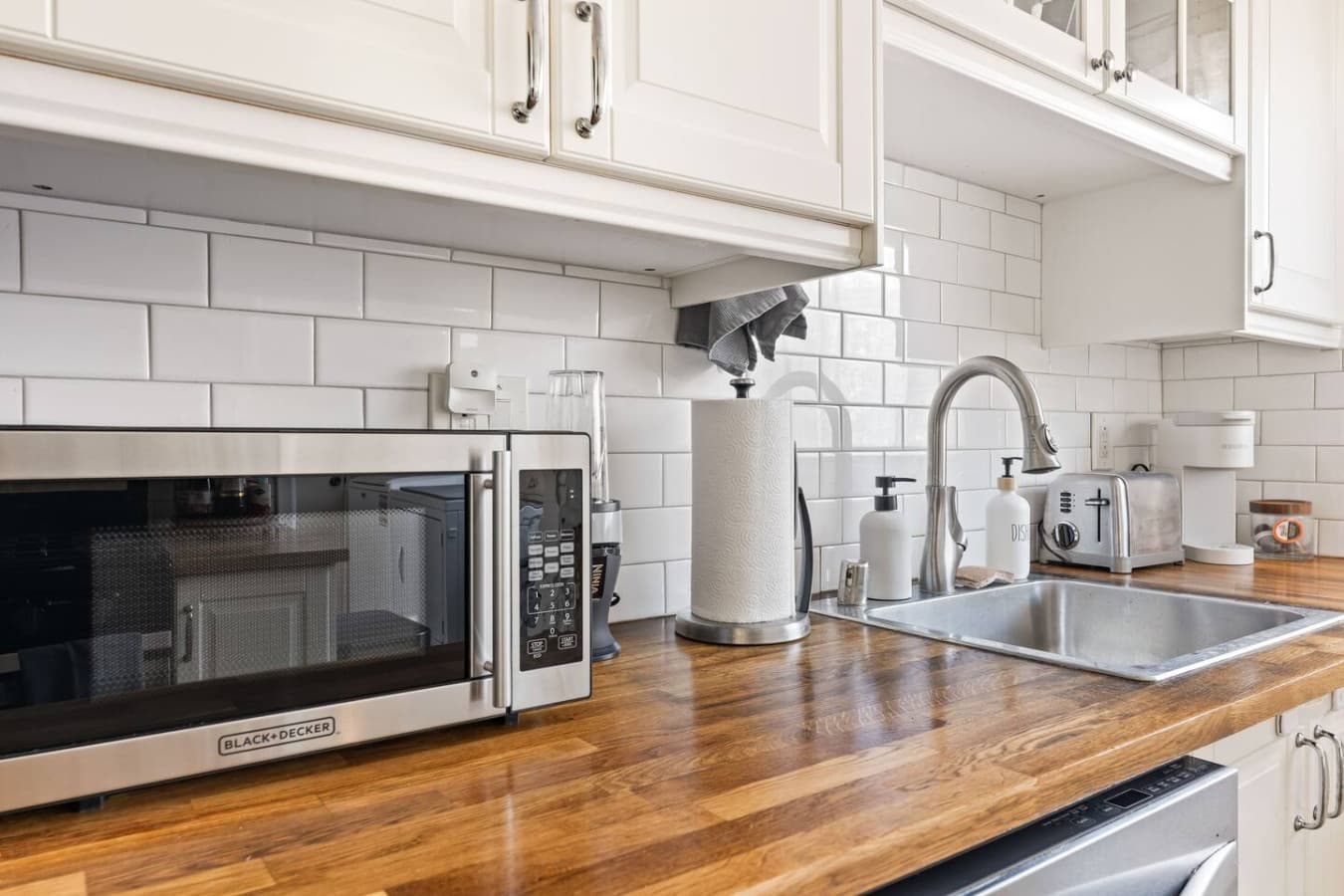 Bright kitchen counter space with subway tile backsplash and convenient small appliances for easy mornings.