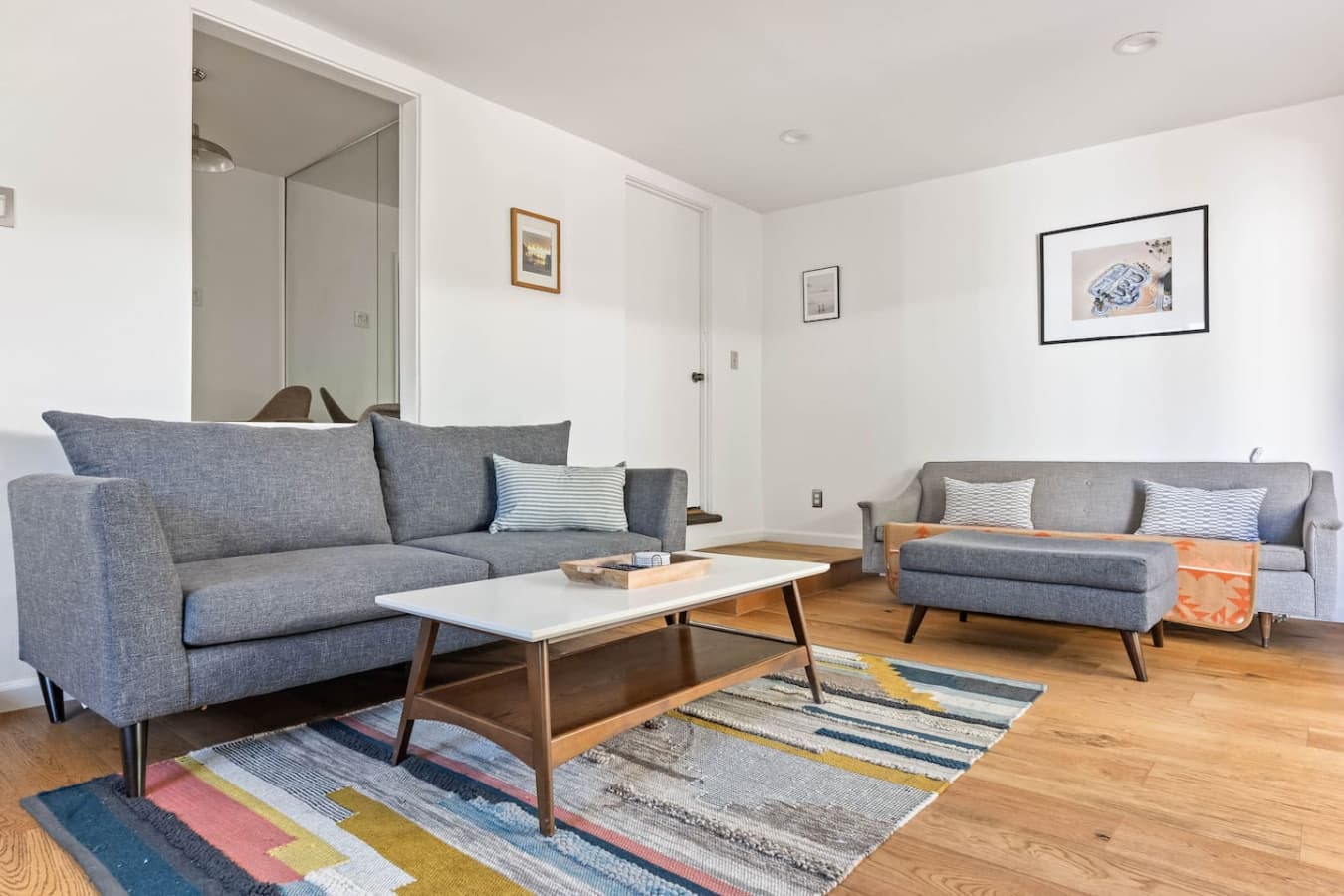 Cozy sectional sofa and coffee table set over a colorful area rug for relaxed evenings in.