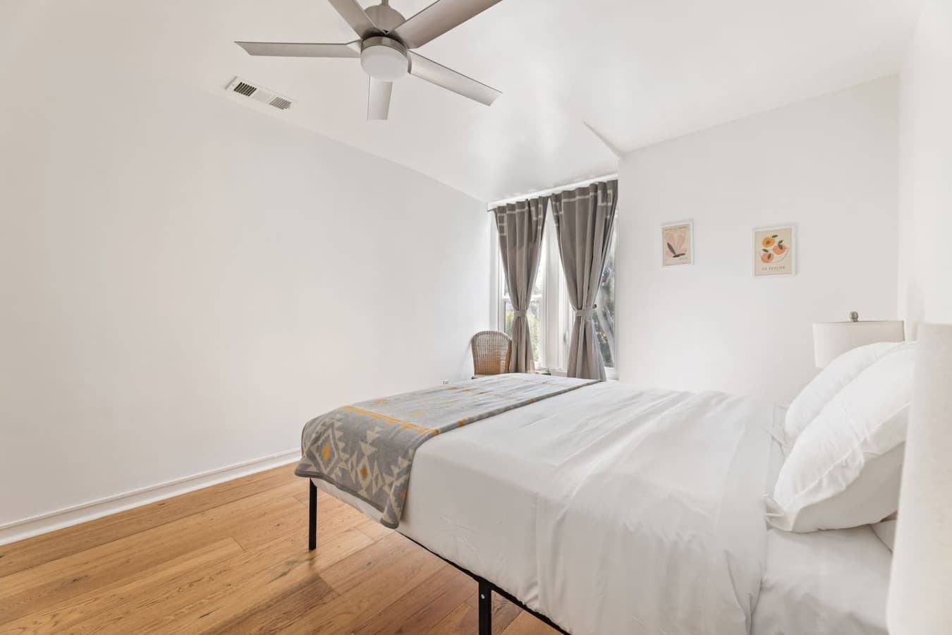 Light filled bedroom with soft curtains and a calming neutral palette.