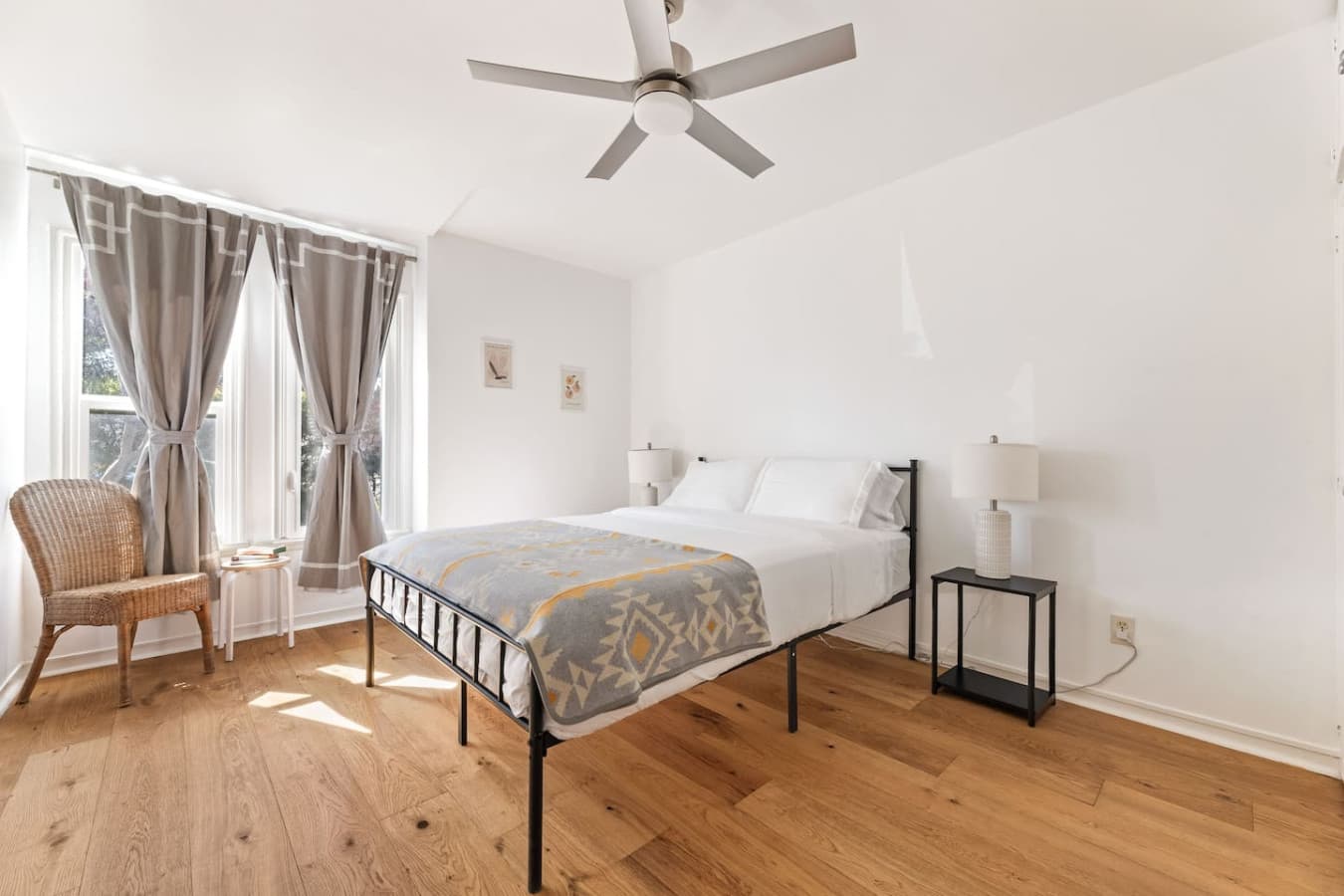 Airy bedroom with warm hardwood floors and bedside lighting for a restful stay.