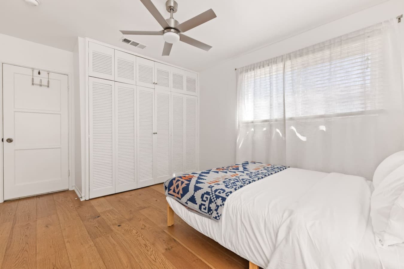 Spacious bedroom featuring ample closet storage and a clean modern design.