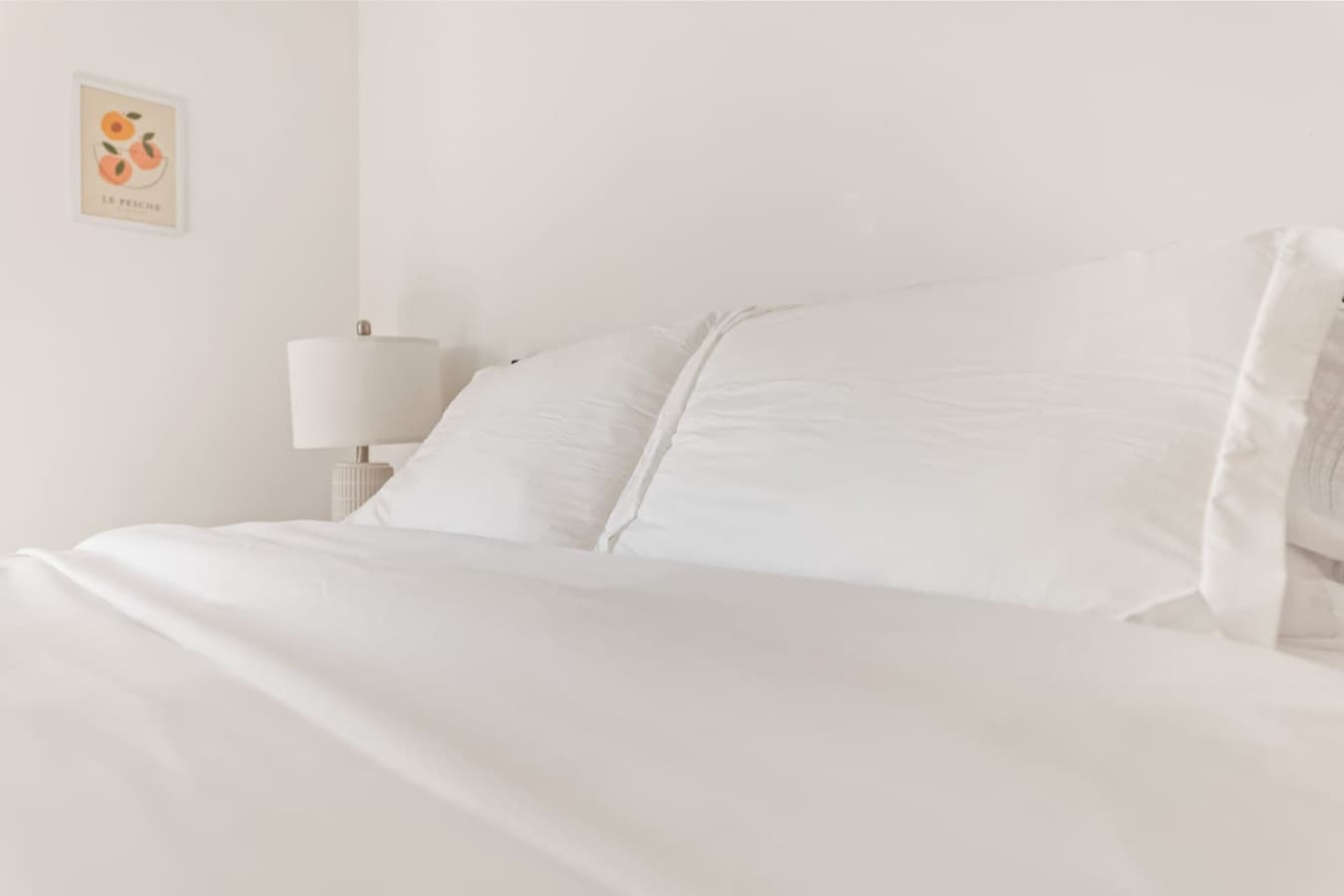 Minimalist bedside setup with crisp white linens for a restful night.
