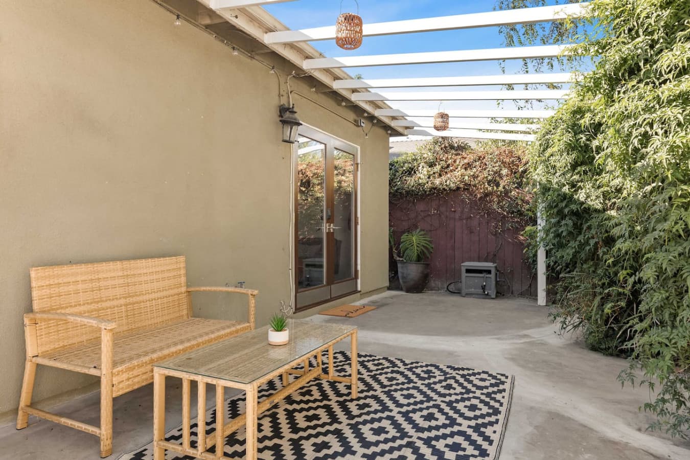 Private patio with pergola, outdoor seating, and a relaxed garden setting.