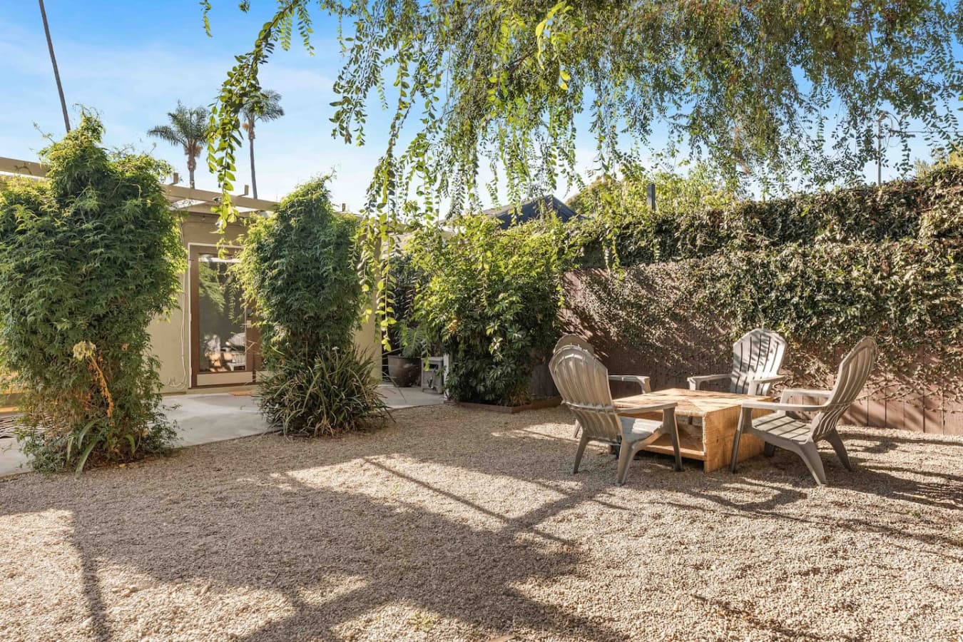 Spacious backyard with gravel landscaping and multiple seating areas to unwind.